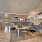 Wohnzimmer mit Sofa, Schaukelstuhl und Küchenbereich