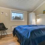 Schlafzimmer mit Bett, Fenster, Schrank und Stuhl.
