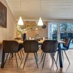 Esszimmer mit Holzwand, Tisch und Stühlen, Fenster zum Garten.