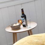 Runde Tisch mit Bier, Gläser und Schale vor weißer Wand