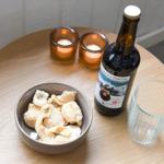 Runde Tisch mit Kerzen, Bier, Gläser und Schale mit Chips.