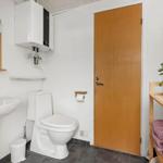 Badezimmer mit Toilette, Waschbecken und Holztür
