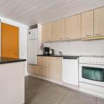 Küche mit Holzschränken, Kühlschrank, Spüle und Kochfeld.
