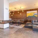 Wohnbereich mit Sofa, Kamin und Holzwand. Moderne Beleuchtung und Wandbilder.