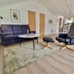 Wohnzimmer mit Sofa, Sessel und Esstisch