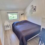 Schlafzimmer mit Bett, Fenster und Kleiderständer