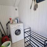 Wäscherei mit Waschmaschine, Trockner und Reinigungsmitteln.