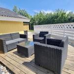 Terrasse mit Sitzgruppe, Holzboden und weißer Umzäunung