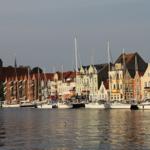 Hafen mit Booten und farbigen Häusern. Kirche im Hintergrund.