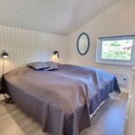 Schlafzimmer mit Bett, Fenster und Spiegel an der Wand.