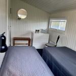 Zwei Betten, Schreibtisch, Spiegel und Fenster in einem Schlafzimmer.