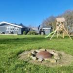 Haus mit Spielplatz und Grillplatz im Garten.