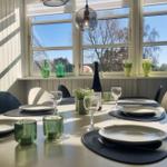 Esstisch mit Platz für sechs Personen, Fenster mit Blick auf Außenbereich.