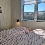 Schlafzimmer mit Bett, Fenster und Wandbildern.