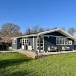 Ein modernes Haus mit Terrasse und Garten. Möblierte Außenterrasse mit Sitzgelegenheiten.