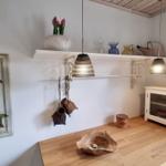 Holzoberfläche mit Schale, Wandregal und Lampen. Weiße Wände und Dekoration.