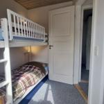 Zimmer mit Doppelstockbett und Tür zum Flur.