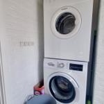 Wäschetrockner und Waschmaschine in einem Raum mit weißen Wänden.