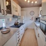 Küche mit weißen Schränken, schwarzer Arbeitsplatte und integriertem Ofen.