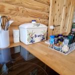 Küchenarbeitsfläche mit Holzwand, Brotkasten und Gewürzdose.