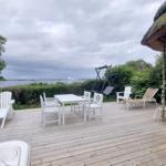 Terrasse mit Tisch, Stühlen und Blick auf Wasser