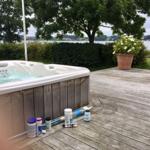 Hochwertige Whirlpool-Terrasse mit Blick auf Wasser und Bäume