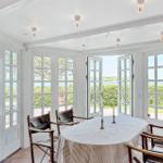 Esszimmer mit runden Tisch, Stühlen und Fenstern zum Garten.