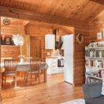 Wohn- und Essbereich mit Küche und Bücherregal in Holzhaus