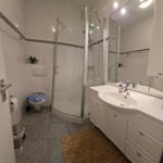 Badezimmer mit Dusche, Waschbecken und Toilette.