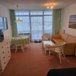 Wohn- und Essbereich mit Sofa, Esstisch und TV.