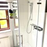 Badezimmer mit Dusche, Waschbecken und Fenster in der Ferienwohnung Harztraum an der alten Stadtmauer in Blankenburg