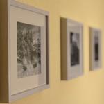 Wand mit drei gerahmten Schwarz-Weiß-Fotografien in hellen Rahmen.