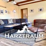 Wohnzimmer mit Sofa, Sessel und Tisch. Holzbalken an der Decke.