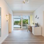 Helle Wohnung mit Blick auf Garten und Terrasse. Schreibtisch, Spiegel und Schlafzimmer sichtbar.