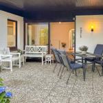 Terrasse mit Sitzgruppe, Tisch und Blumen. Durchgang zur Wohnung.