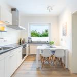 Küche mit Essbereich, Fenster und moderner Einrichtung.