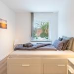 Schlafzimmer mit Bett, Fenster und Wandbild.