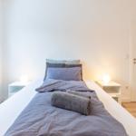 Schlafzimmer mit Bett, Nachttischen und Fenster