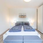 Schlafzimmer mit Doppelbett, zwei Nachttischen und Kleiderschrank.