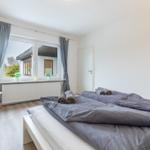 Schlafzimmer mit Doppelbett, Fenster und Stuhl.