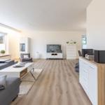 Wohnzimmer mit Sofa, TV und Holzboden.