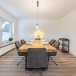 Esszimmer mit Holztisch, grauen Stühlen und Fensterblick.