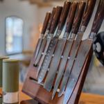 Küchenmesser mit Holzgriffen in einem Holzhalter auf Tisch