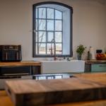 Küche mit Waschbecken, Fenster und Holzoberflächen