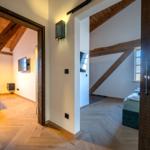 Zwei Räume mit Holzbalken, Hölzern und Fernsehern sind sichtbar.