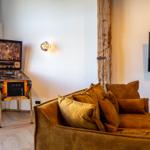 Ein braunes Sofa mit Kissen, eine Pinball-Maschine und eine Wandlampe.
