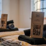 Bett mit gefalteten Handtüchern und Bio-Duschset.