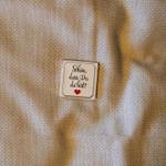 Ein kleines Schild mit der Aufschrift Schön, dass Du da bist! und einem Herzen auf Stoff.