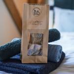 Bio-Produkte in Papierbeutel auf gefalteten Handtüchern auf Bett