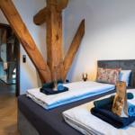 Schlafzimmer mit massivem Holzgestell und Bett mit Kissen.